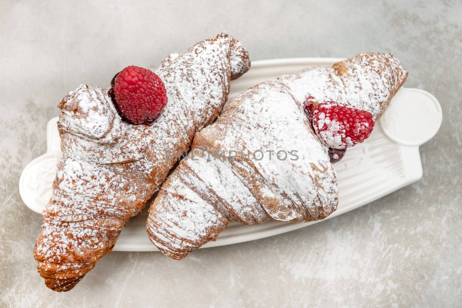 Croissants with jam and berries for Breakfast. Behind, a defocus background.