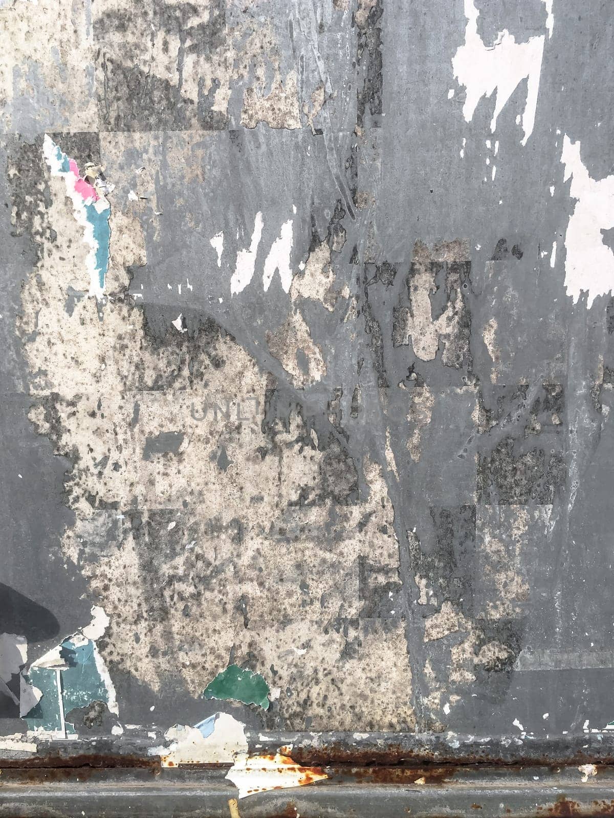 Grunge ripped poster background. Texture of torn advertisement on an old rusty billboard panel.