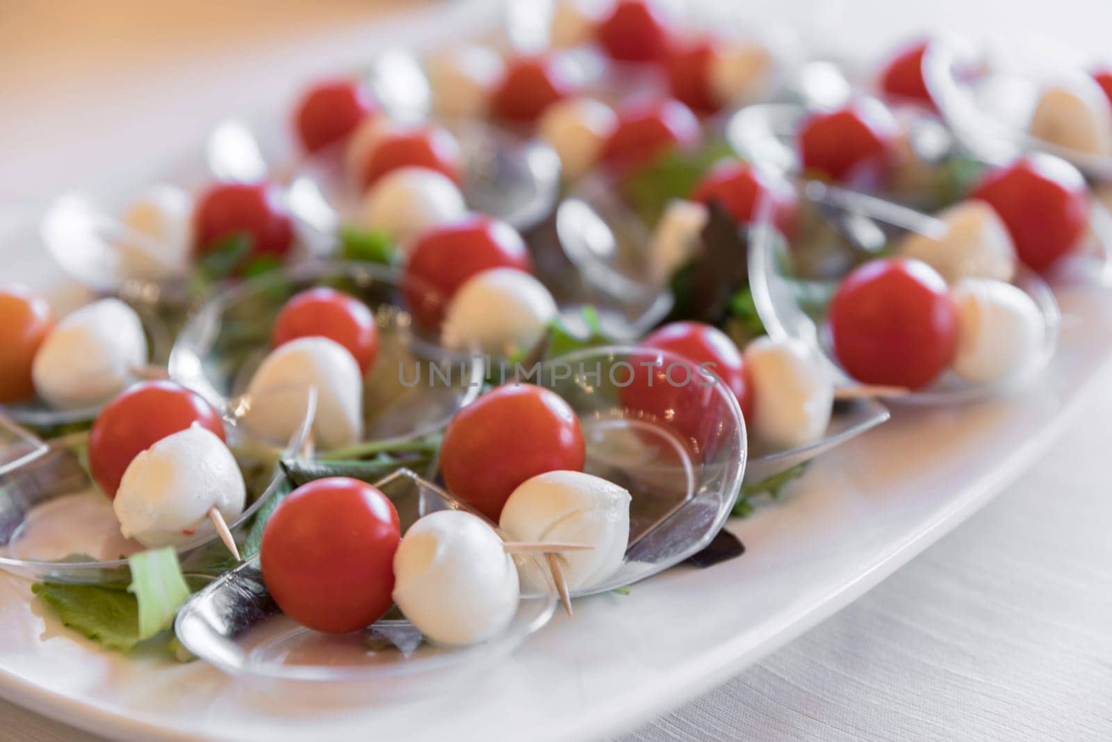 Italian food. Caprese salad with tomato, mozzarella and basil. Party. Holiday. Selective focus.