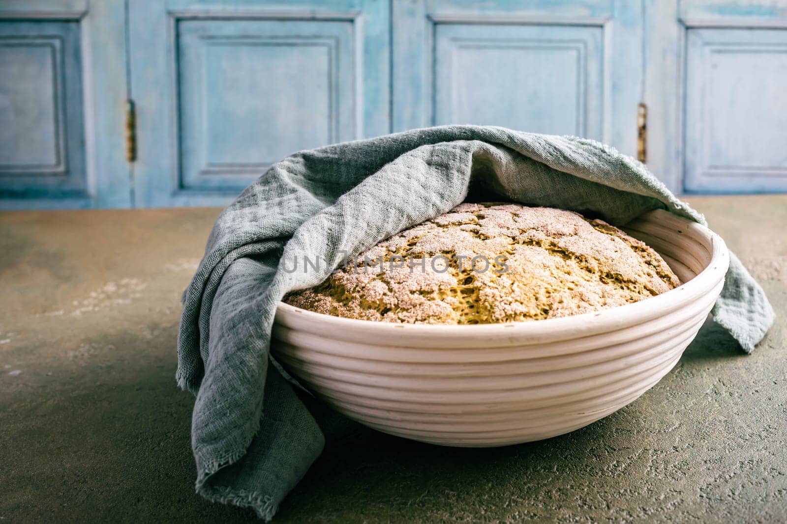 Homemade spelt bread with herbs and wild garlic, process of raising dough in a special basket. Dough made from natural sourdough, fermentation process