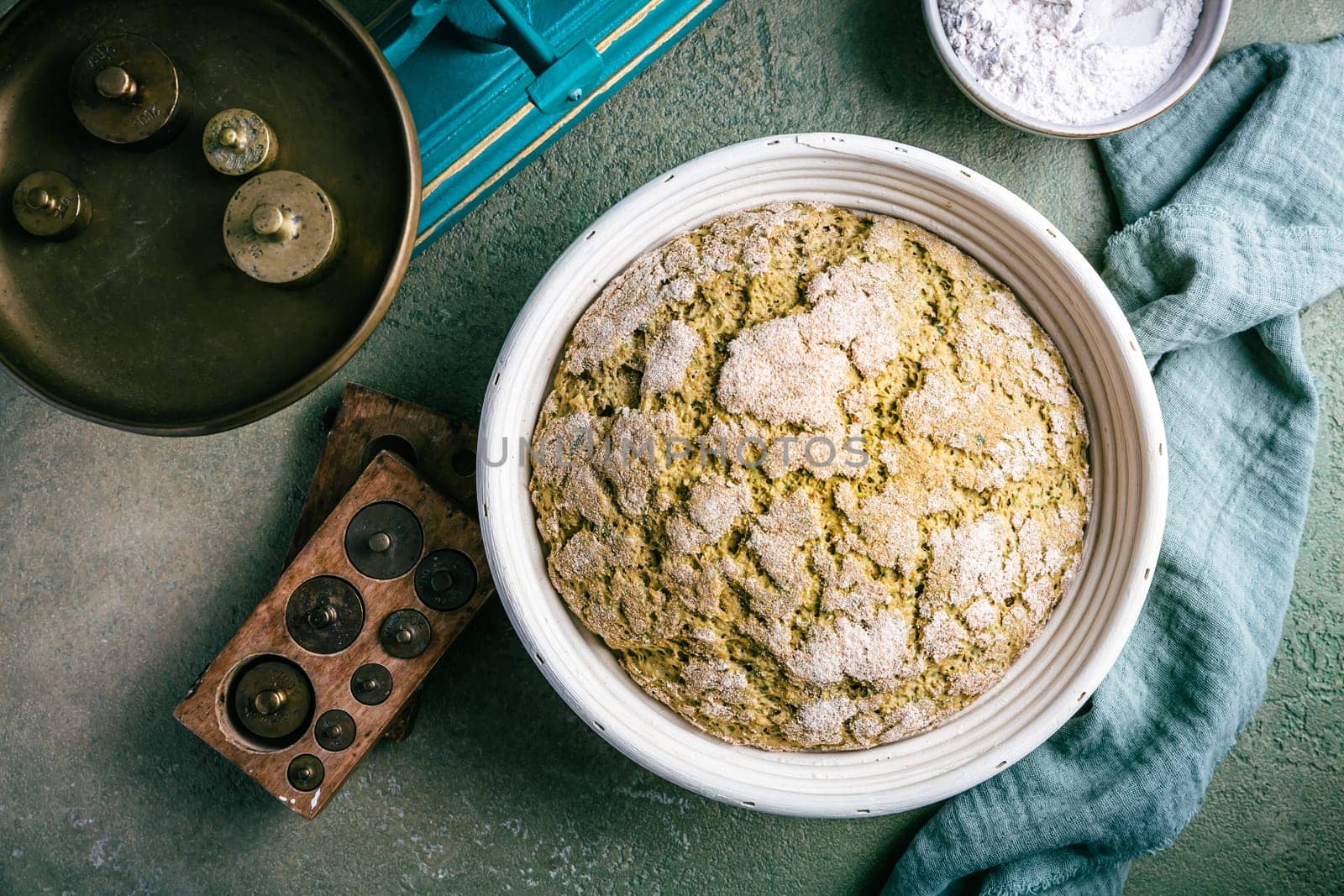 Homemade spelt bread with herbs and wild garlic, process of raising dough in a special basket. Dough made from natural sourdough, fermentation process
