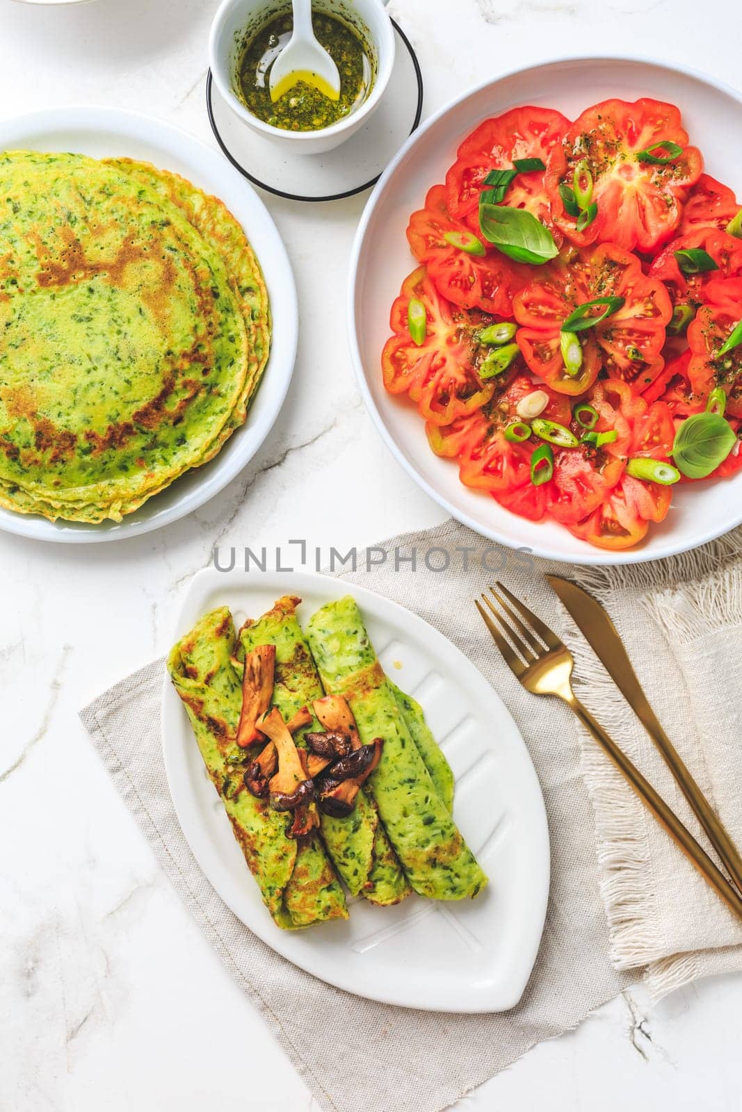 Savory wirld garlic (ramson, bear leek, Allium ursinum) pancakes with tomato salad