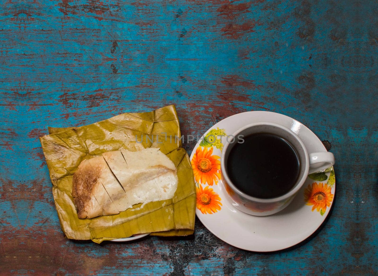 Traditional Stuffed Pisque Tamal with cup of coffee served on wooden table, Central American typical food Stuffed Tamal Pisque, Stuffed tamale with cup of coffee served on wooden table