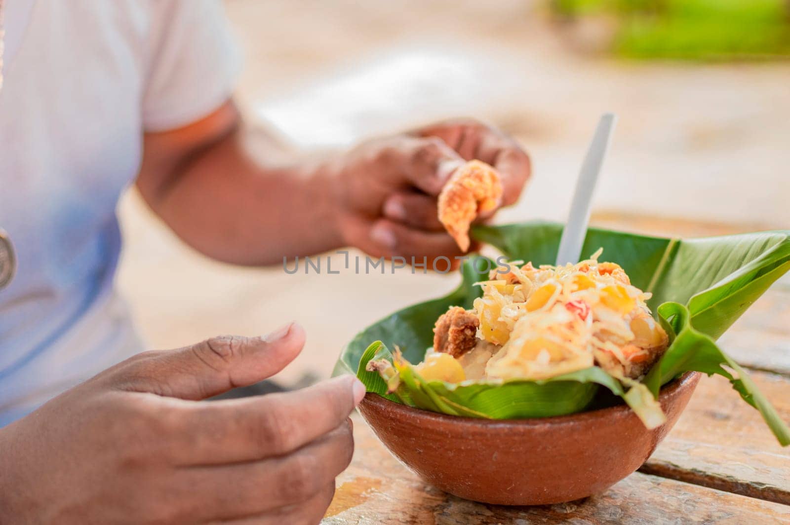 Close-up of person eating vigoron on table. Local person eating a traditional vigorón. The vigoron typical food of Granada, Concept of typical food of Nicaragua