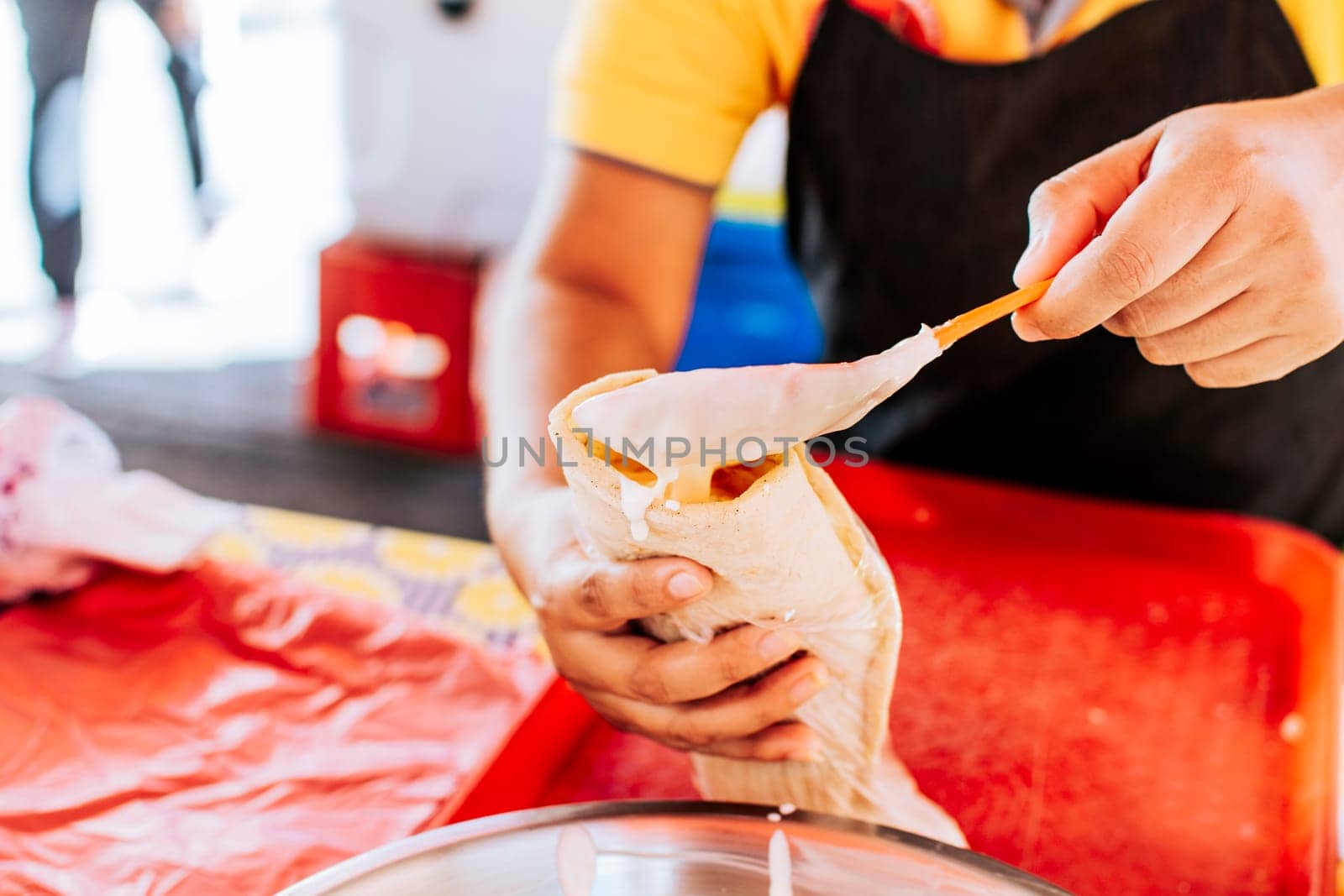Close up of hands making a traditional quesillo with pickled onion. Hands making a delicious quesillo. Preparation of Nicaraguan quesillo, traditional Central American food quesillo
