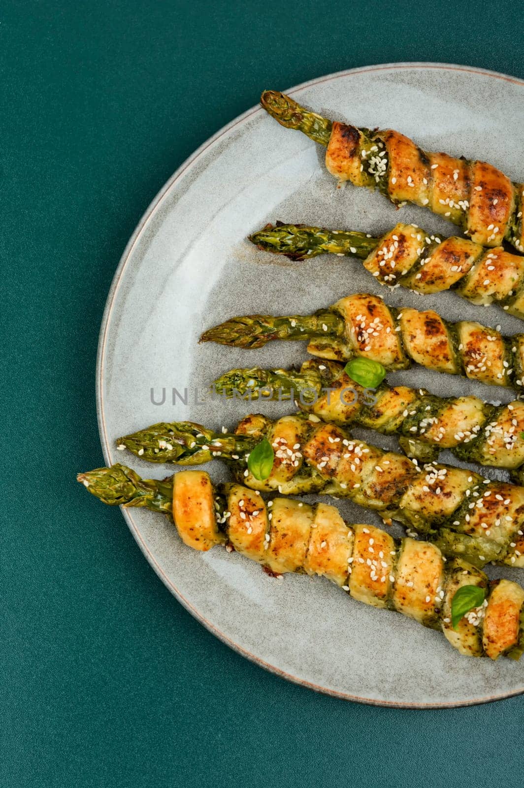 Dietary bread sticks stuffed with asparagus and pesto sauce on a plate.