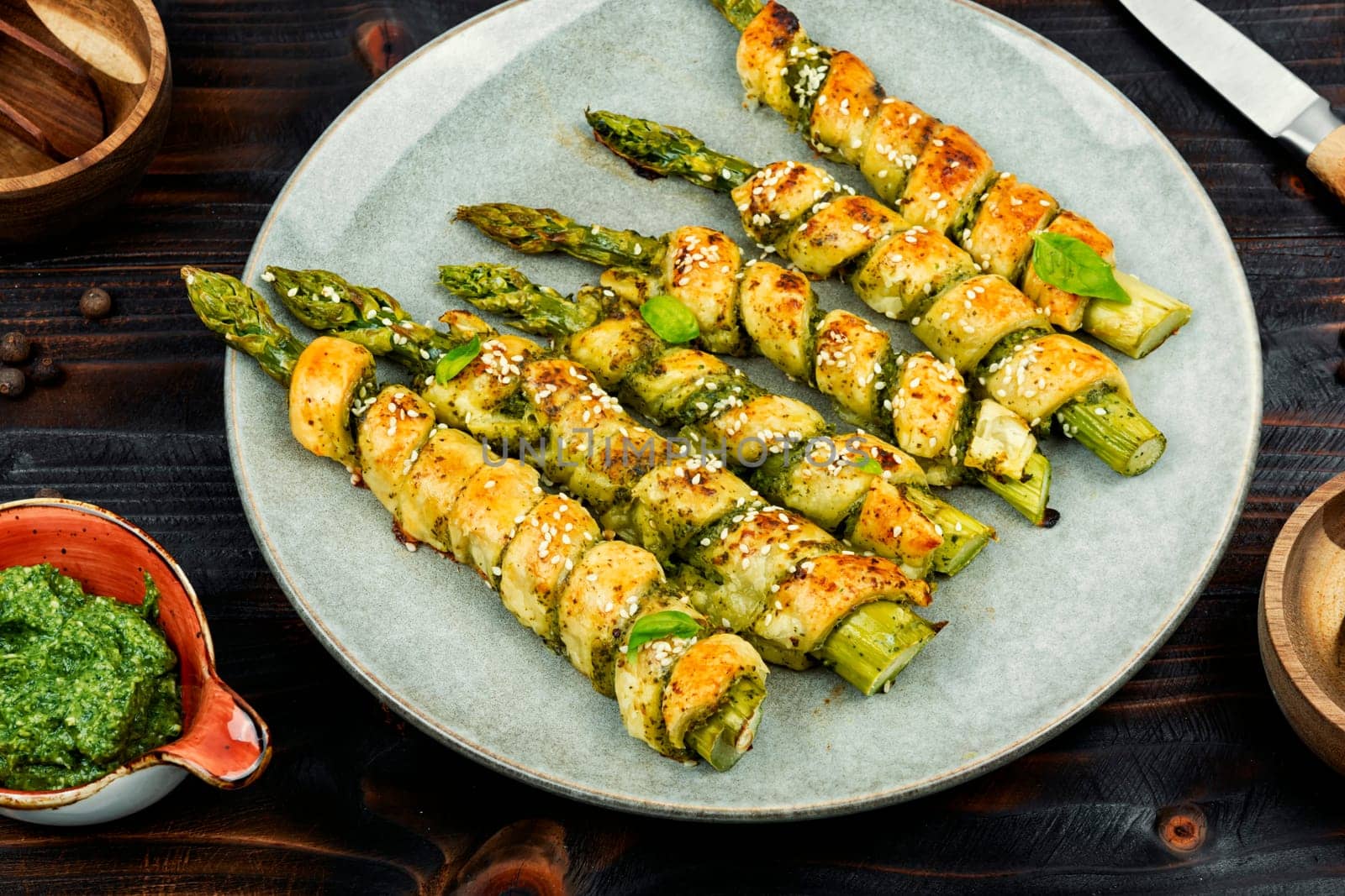 Dietary bread sticks stuffed with asparagus and pesto sauce on a plate.