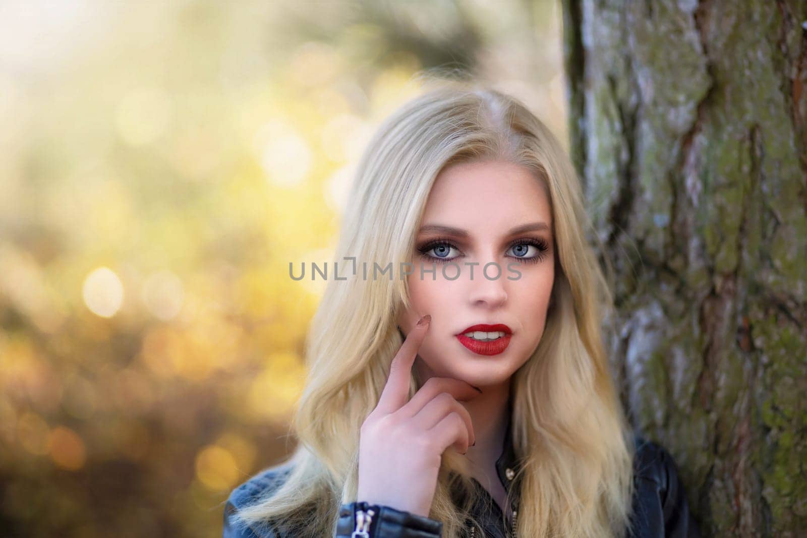 Sexy long hair girl with red lips is posing touching face by finger.  Horizontally.