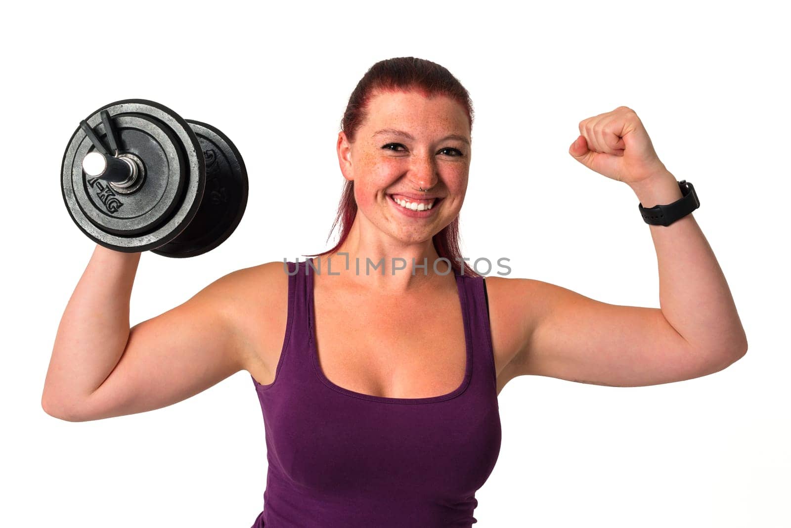 Young beautiful red-haired fitness female excersises with dumbbell, isolated on white background
