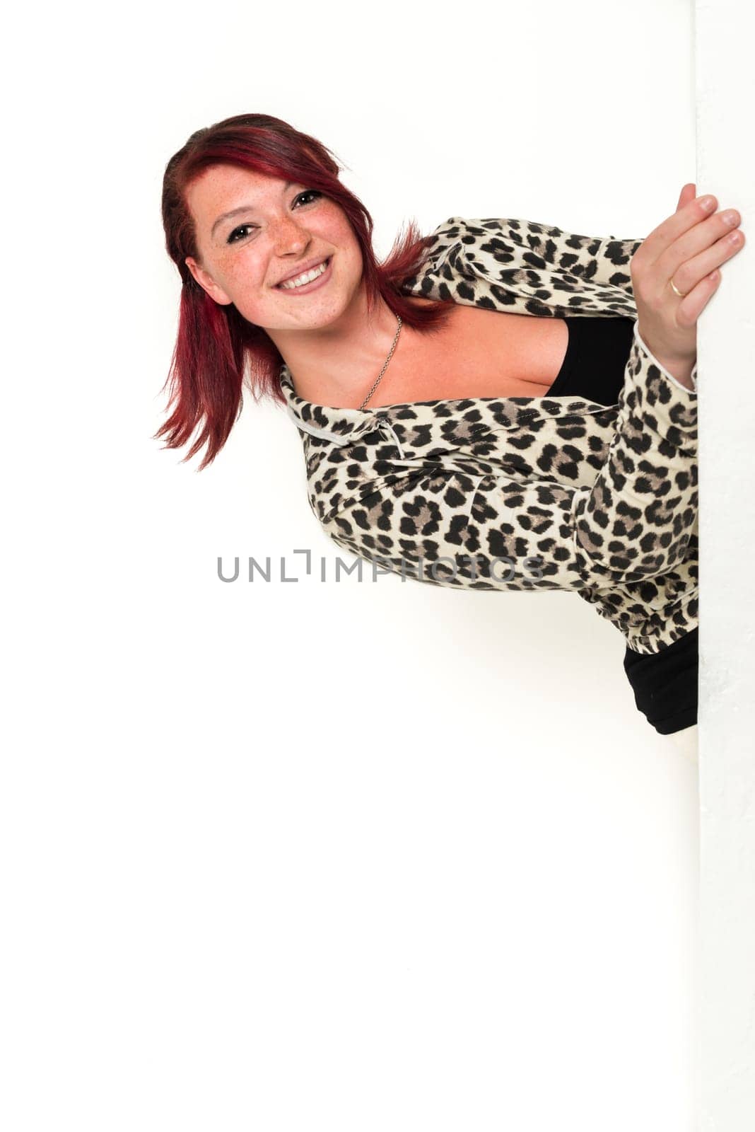 Young lovely red-haired woman looking around the corner, fashion, tiger look, on white background
