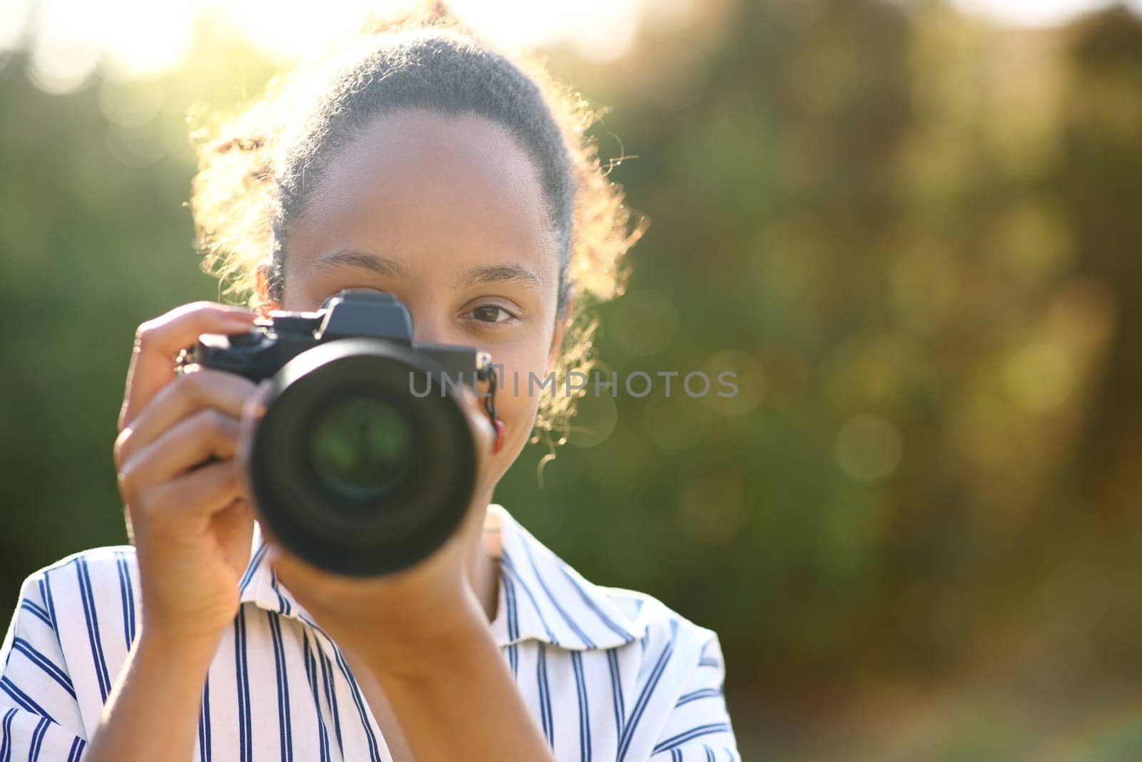 Front view of a black photographer taking photo of you