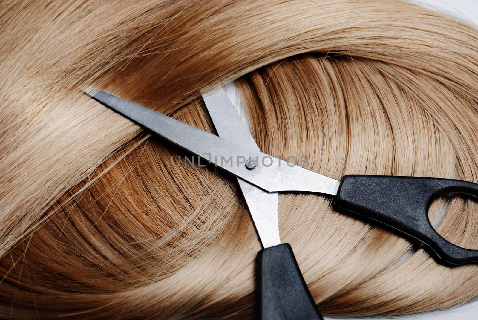 Long healthy blonde hair and professional scissors