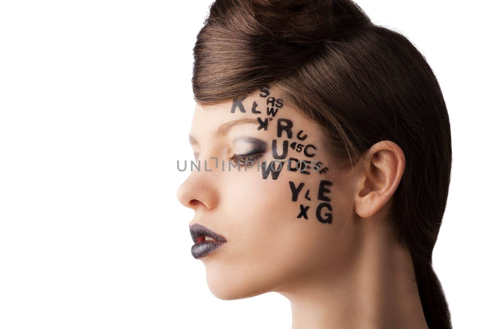 very cute young girl with letter and number painted on her face and a nice creative hair style, she is turned in profile at right and looks down