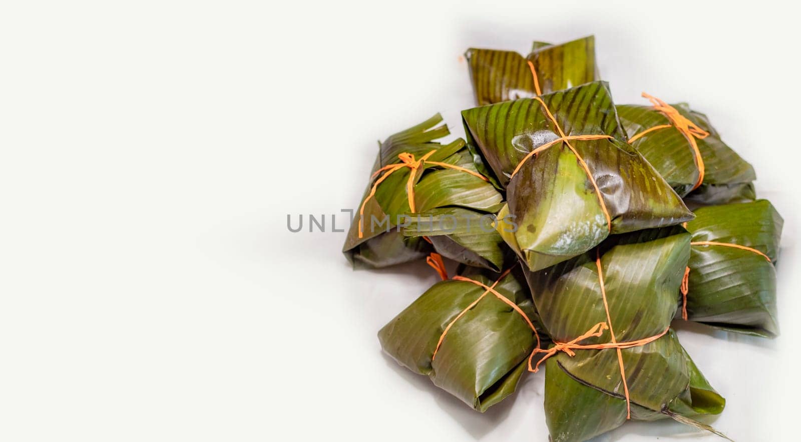View of homemade Nicaraguan nacatamales with banana leaf on white background, Traditional food Mexican Nacatamales isolated. Traditional Nacatamales in banana leaves isolated
