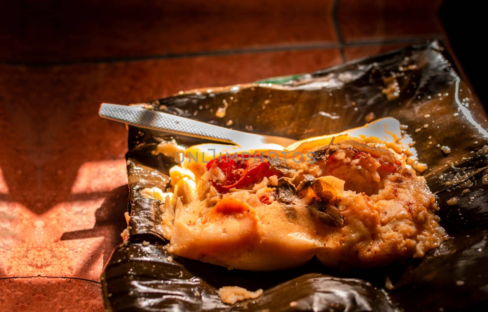 Close up of Nicaraguan Nacatamal ready to eat, Typical Nicaraguan Nacatamal freshly made served on the table. Homemade Nicaraguan Nacatamal, Traditional Nacatamal served in banana leaf