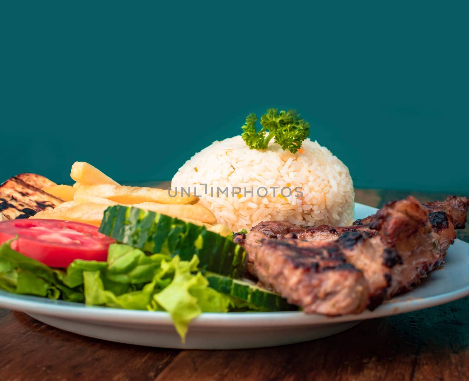 Roast chicken close-up with tomato salad and french fries, Roast chicken traditional food served on wooden table, plate with roasted chicken and rice served on wooden background