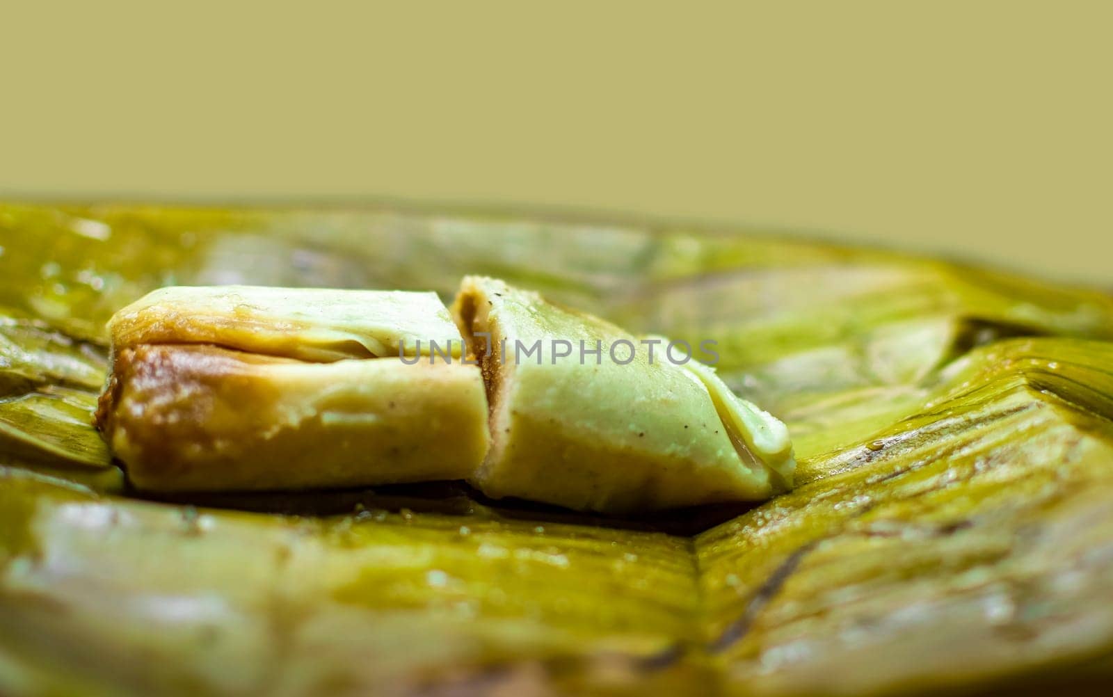 Stuffed tamale served in banana leaves. Close up of a traditional tamale on a banana leaf. Nicaraguan pisque tamale on banana leaf. Tamalpisque traditional Central American food