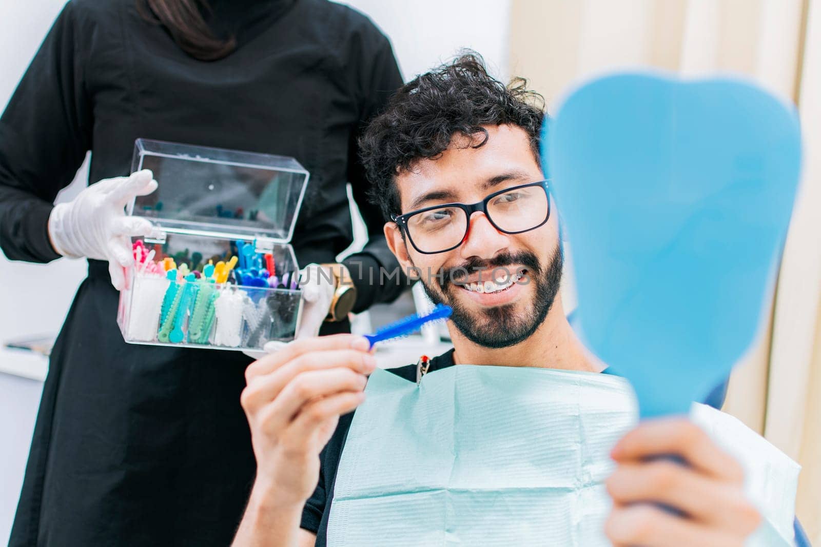 Dentist with patient choosing metal braces, Patient with dentist choosing rubber band, Patient with dentist choosing dental braces