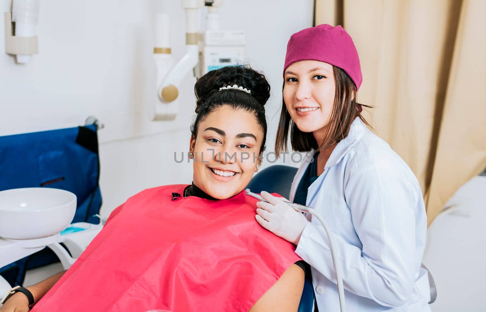 Female dentist with smiling female patient looking at camera, Professional dentist with female patient in office, Portrait of smiling dentist with female patient in medical office