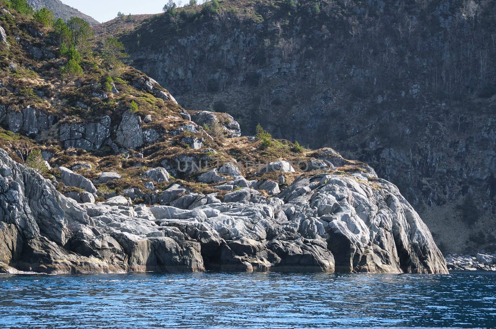 Norway, mountain reaches into fjord. Steep slopes in the background. Fjord landscape. Landscape photo from the north