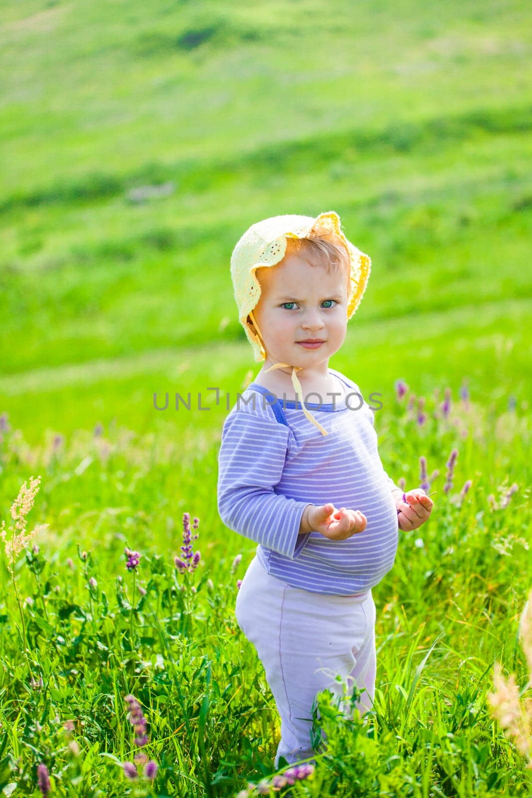 Portrait of 1 year old baby girl enjoying a day on a meadow.