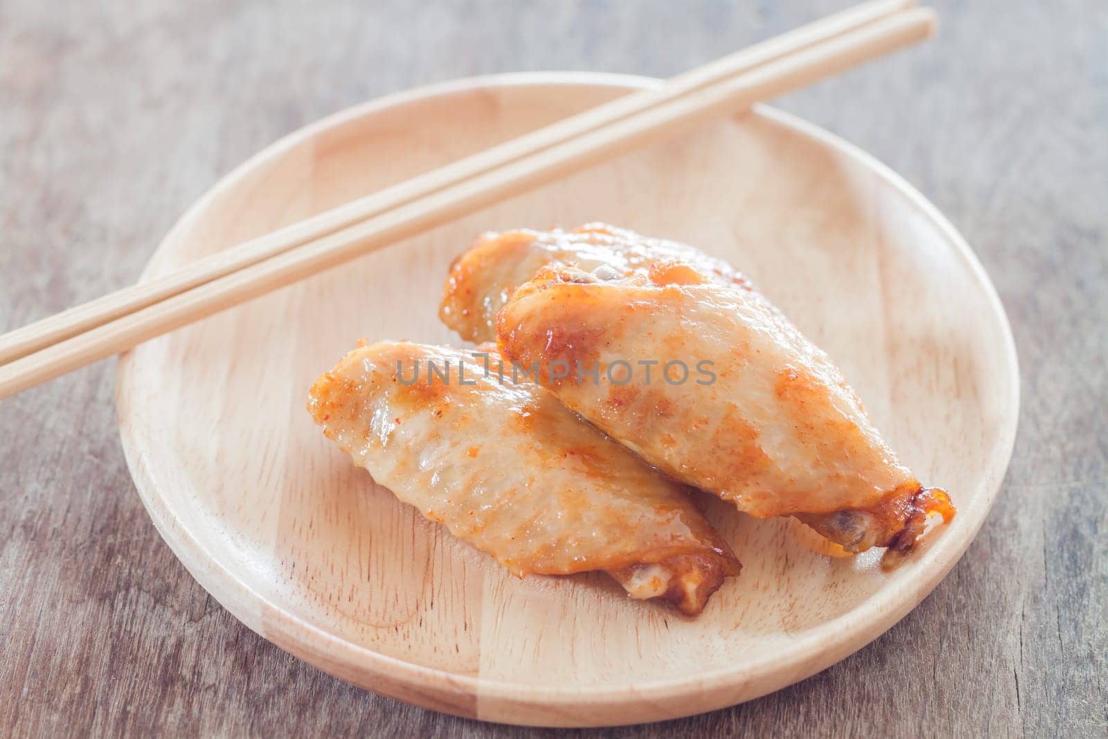 Grilled chicken wings on wooden plate, stock photo