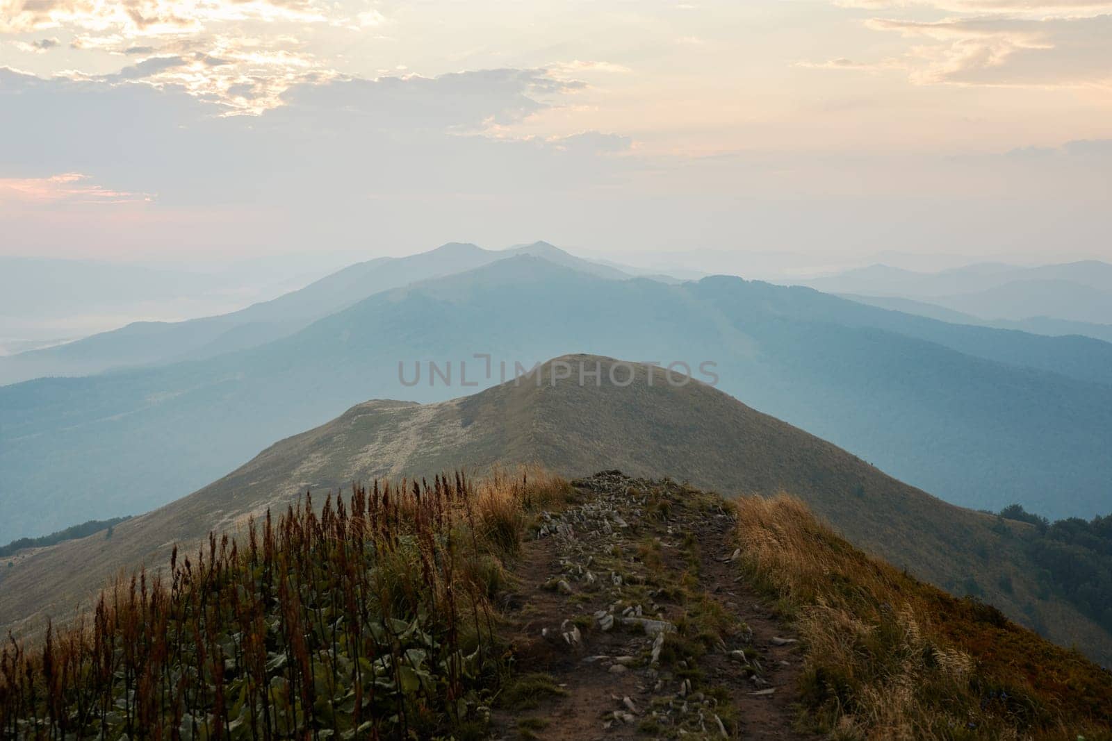 Mountain landscape. Scenic view of mountain peaks, slopes, hills and valleys covered with foggy slopes and valleys. Panoramic view. Natural scenery. Beautiful background