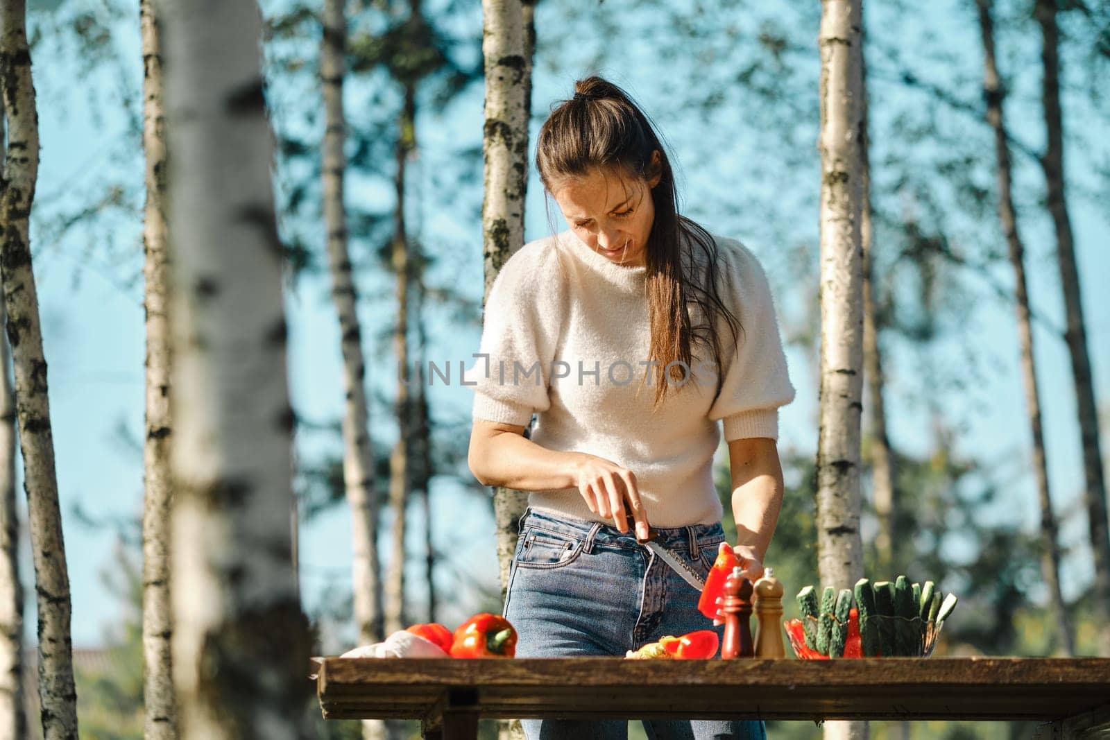 Woman peeling seeds from bell pepper while making food outdoor