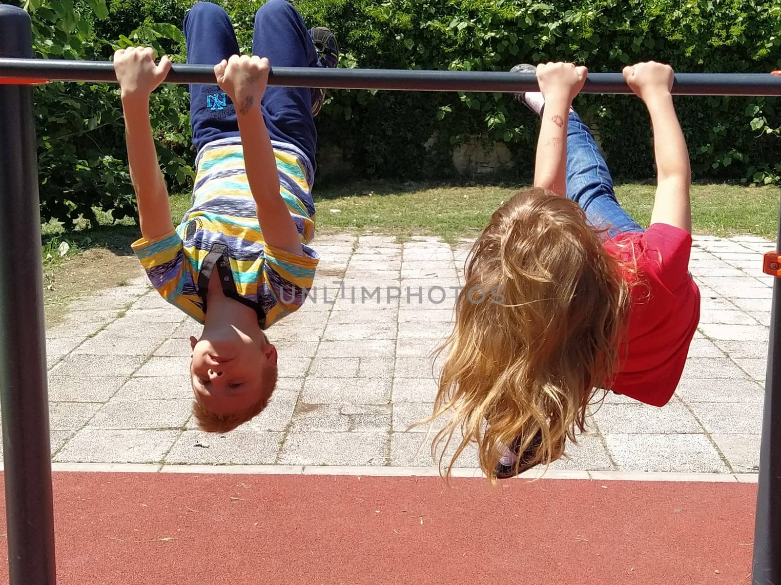 Sremska Mitrovica, Serbia. June 6, 2020. Flip-flops, weight lifting and weights, strength exercises. Two teenagers go in for sports on simulators, children on a sports ground.