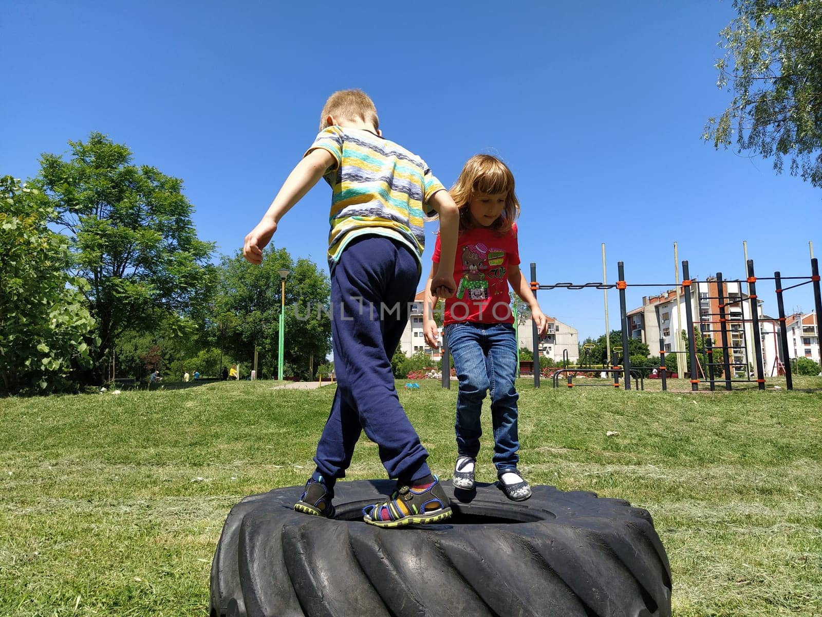 Sremska Mitrovica, Serbia. June 6, 2020. Flip-flops, weight lifting and weights, strength exercises. Two teenagers go in for sports on simulators, children on a sports ground.