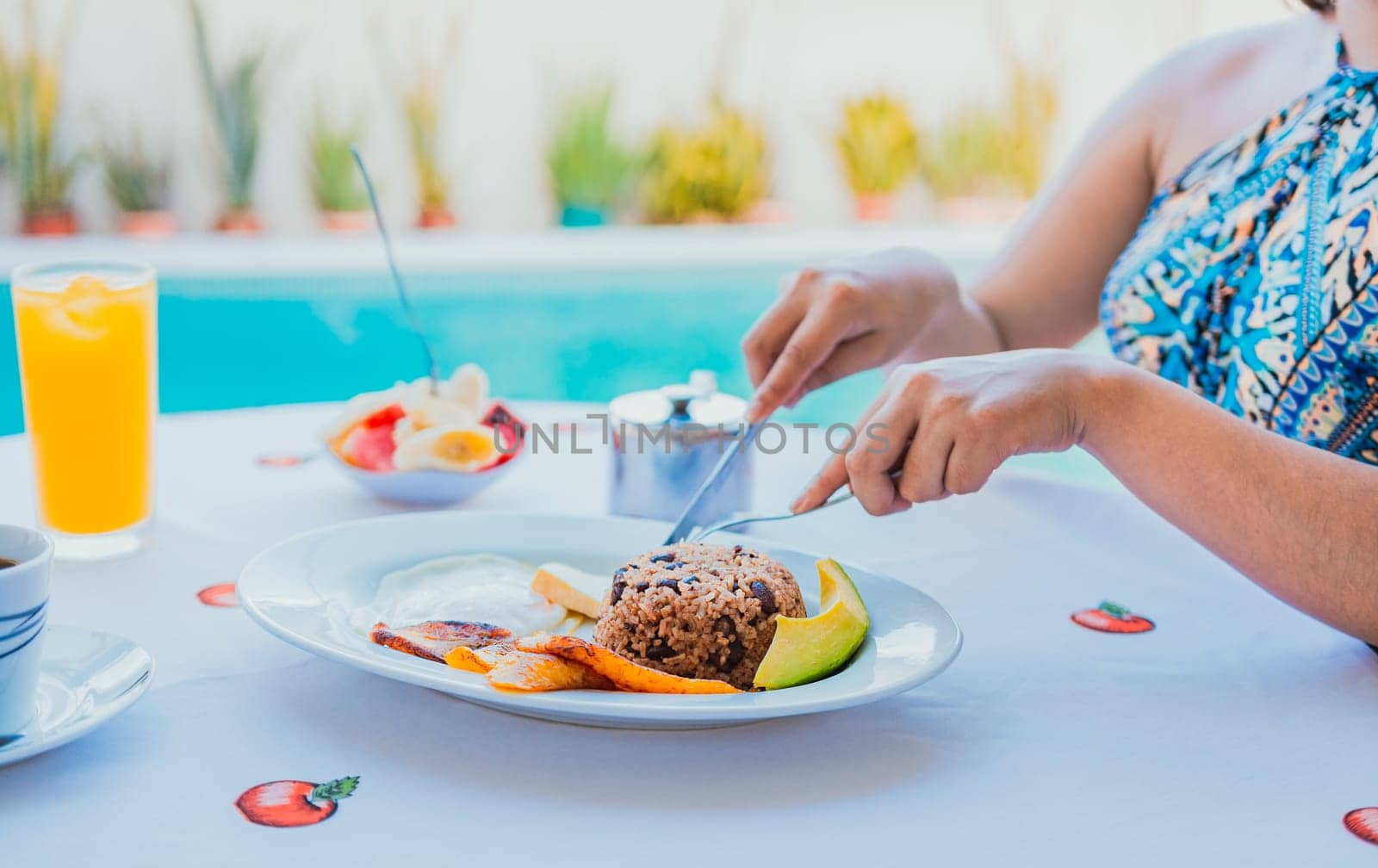 Breakfast near the swimming pool. hands of girl with a breakfast near the pool