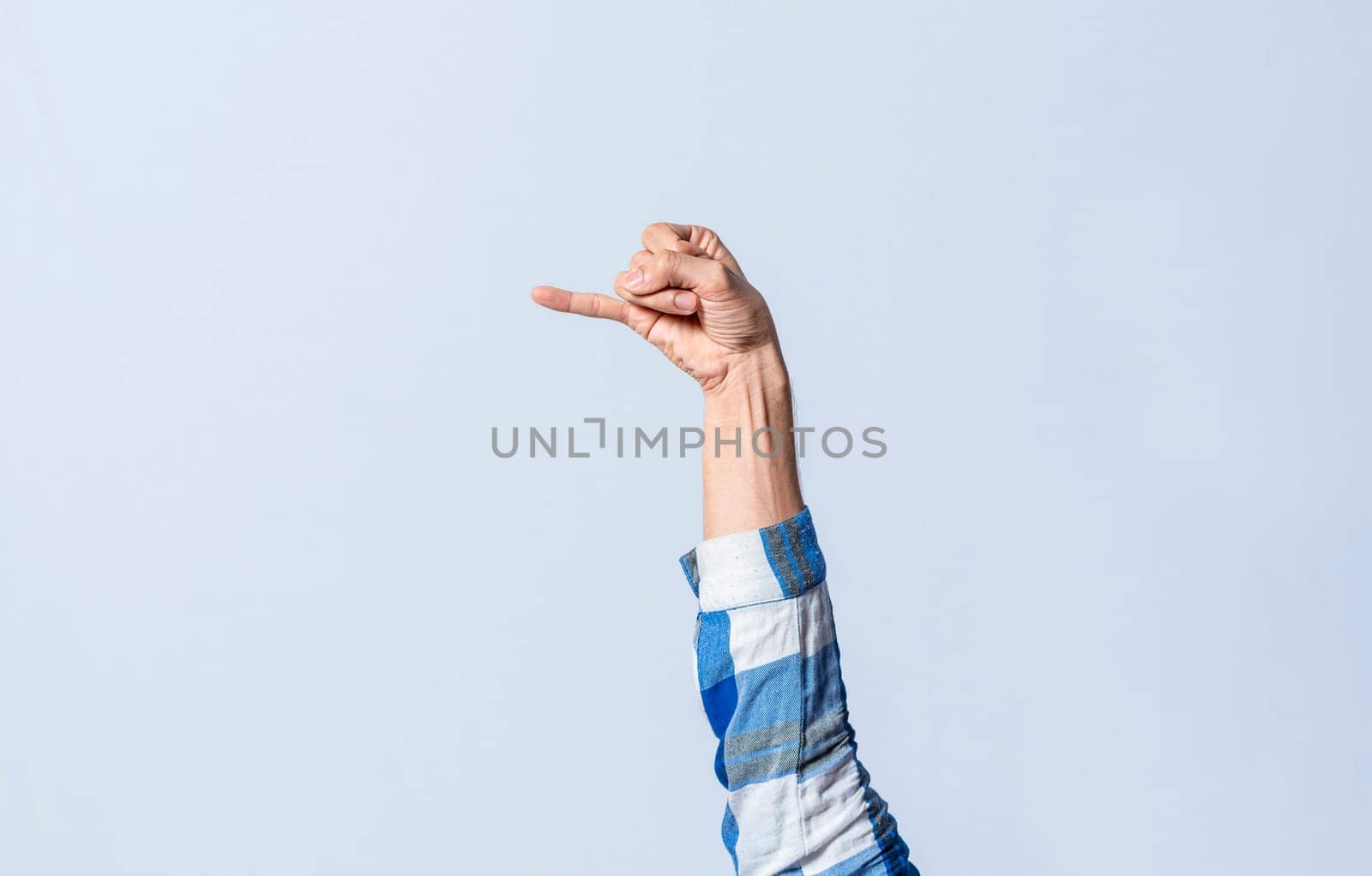 Hand gesturing the letter J in sign language on an isolated background. Man's hand gesturing the letter J of the alphabet isolated. Letters of the alphabet in sign language
