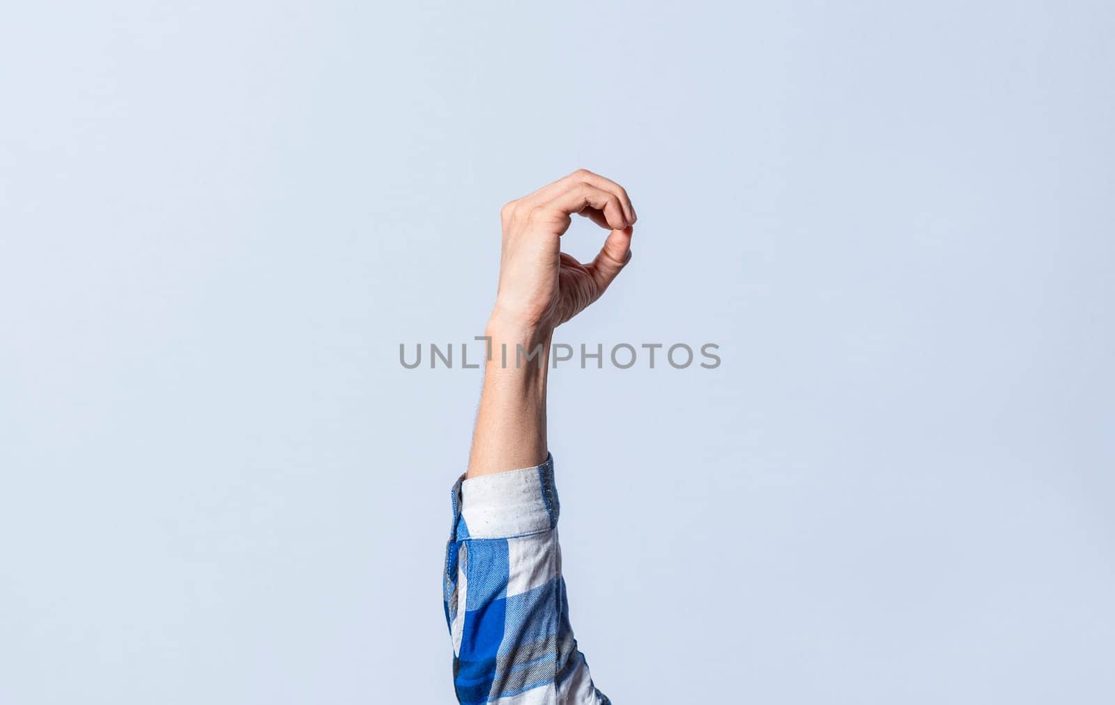 Hand gesturing the letter O in sign language on an isolated background. Man's hand gesturing the letter O of the alphabet isolated. Letter O of the alphabet in sign language