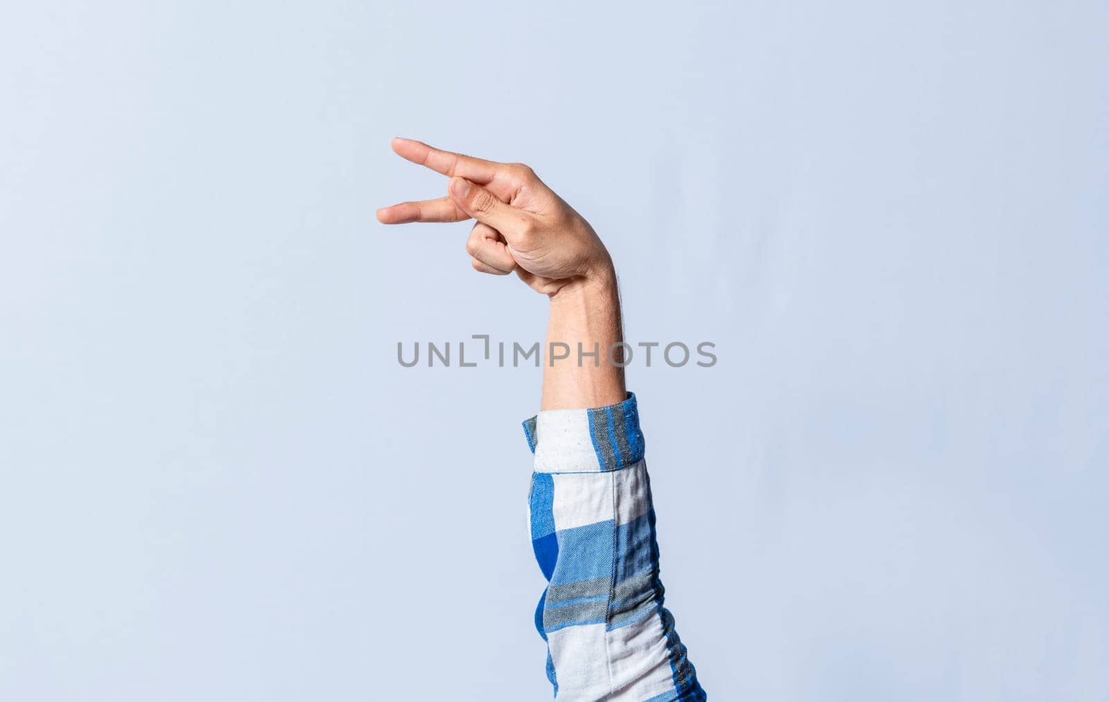 Hand gesturing the letter P in sign language on an isolated background. Man's hand gesturing the letter P of the alphabet isolated. Letter P of the alphabet in sign language