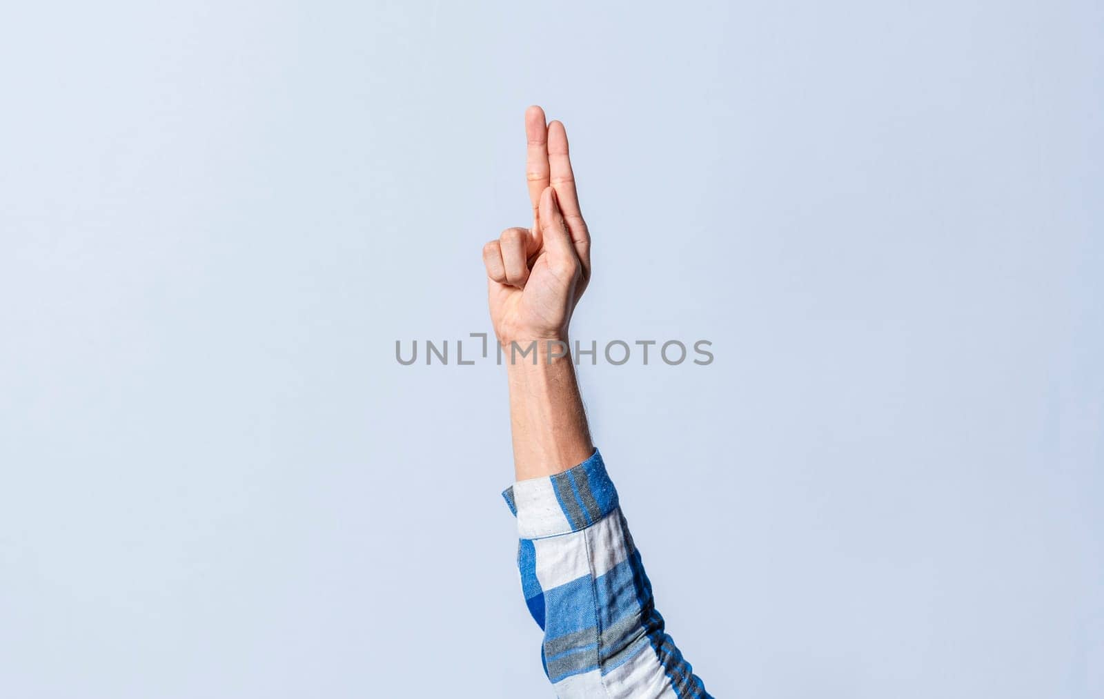 Hand gesturing the letter U in sign language on an isolated background. Man's hand gesturing the letter U of the alphabet isolated. Letter U of the alphabet in sign language