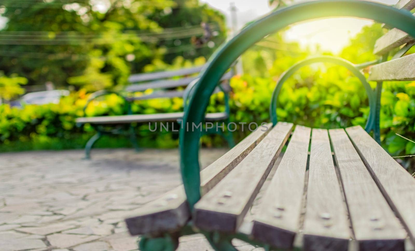 Low angle view of a lonely bench in the park with out of focus background, Wooden bench with blur background with copy space. low angle view of a bench in a park