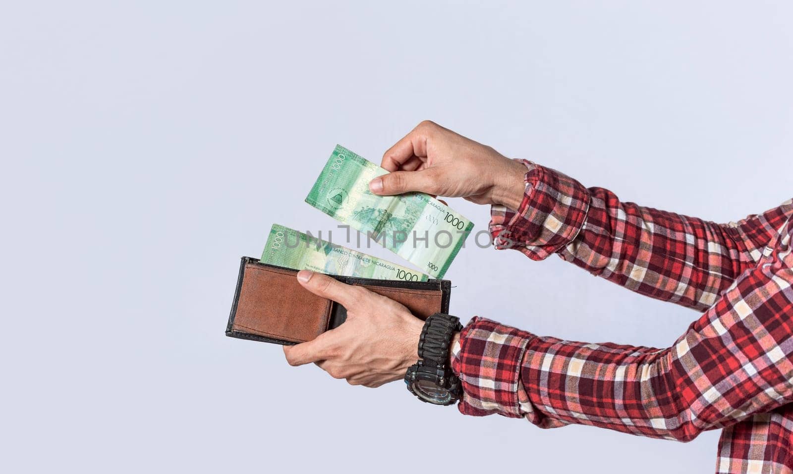 Man taking money out of his wallet, close up of hands taking money out of his wallet isolated, Nicaraguan banknotes, cash payment concept