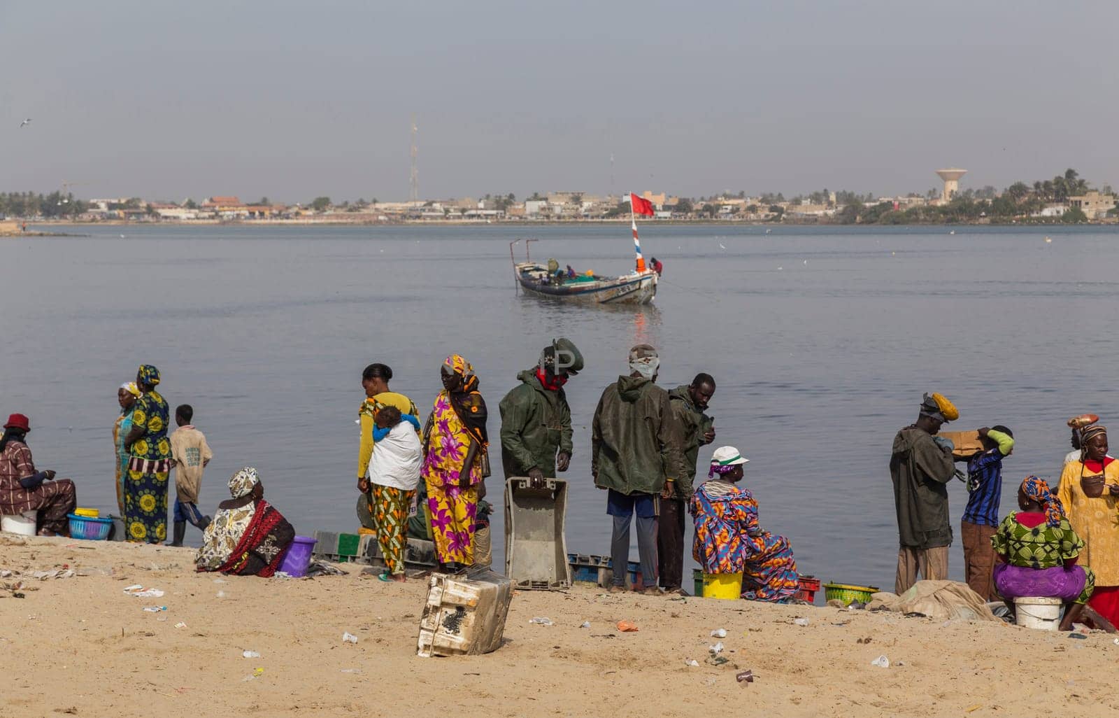 Dakar, Senegal. August 18, 2019: People buying and selling just landed fish on beach at Dakar, Senegal, West Africa