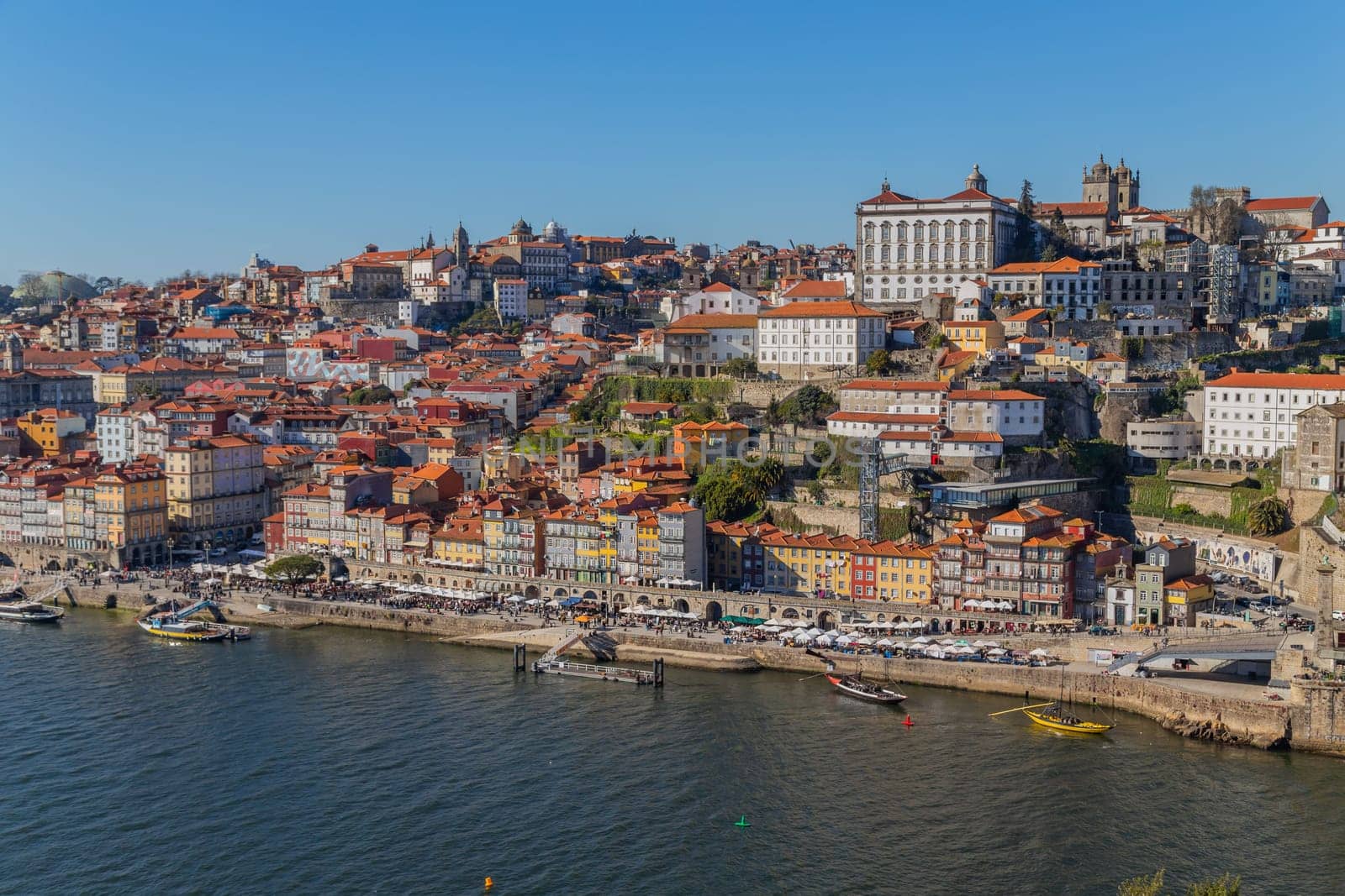 Porto, Portugal - March 02, 2023: View of Ribeira historical quarter on the margin Douro river embankment in the old town and Luis I bridge, Porto, Portugal.