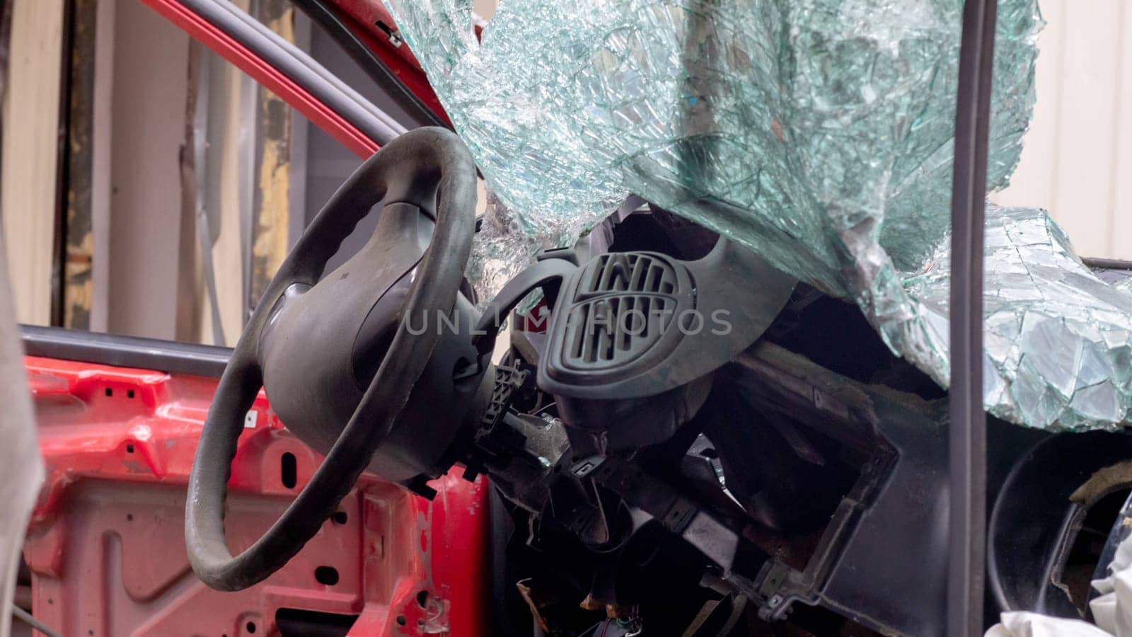 Broken rumpled red car after a severe accident with a skewed body, after a powerful blow. Accident on the street, damaged car after a collision in the city. Auto accident. Broken car on the street