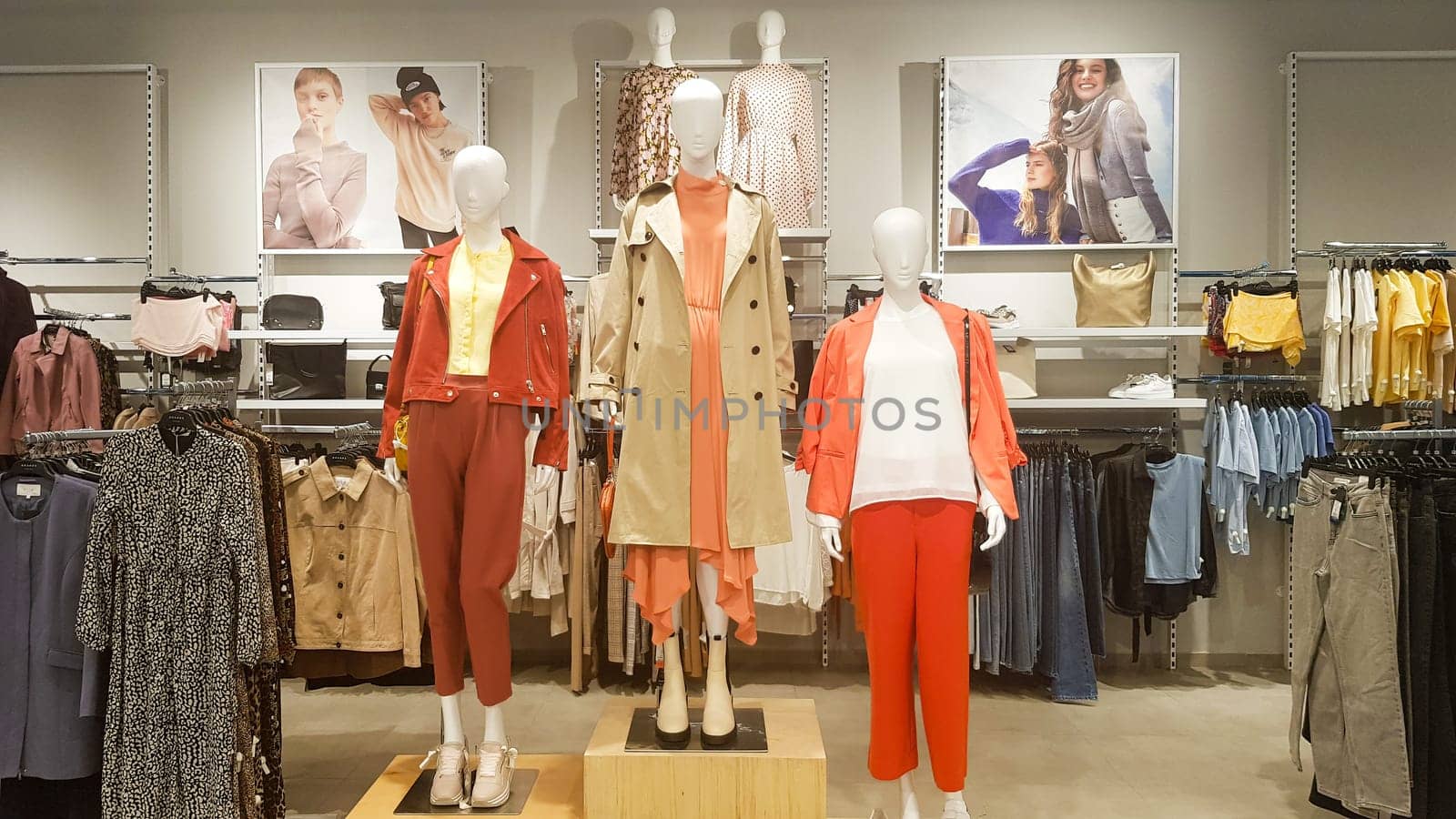 Three dressed mannequins standing in a store. Casual women's clothing store in the mall. Boutique mannequins in a fashion store. Shopping store without people. Ukraine, Kyiv - May 23, 2022