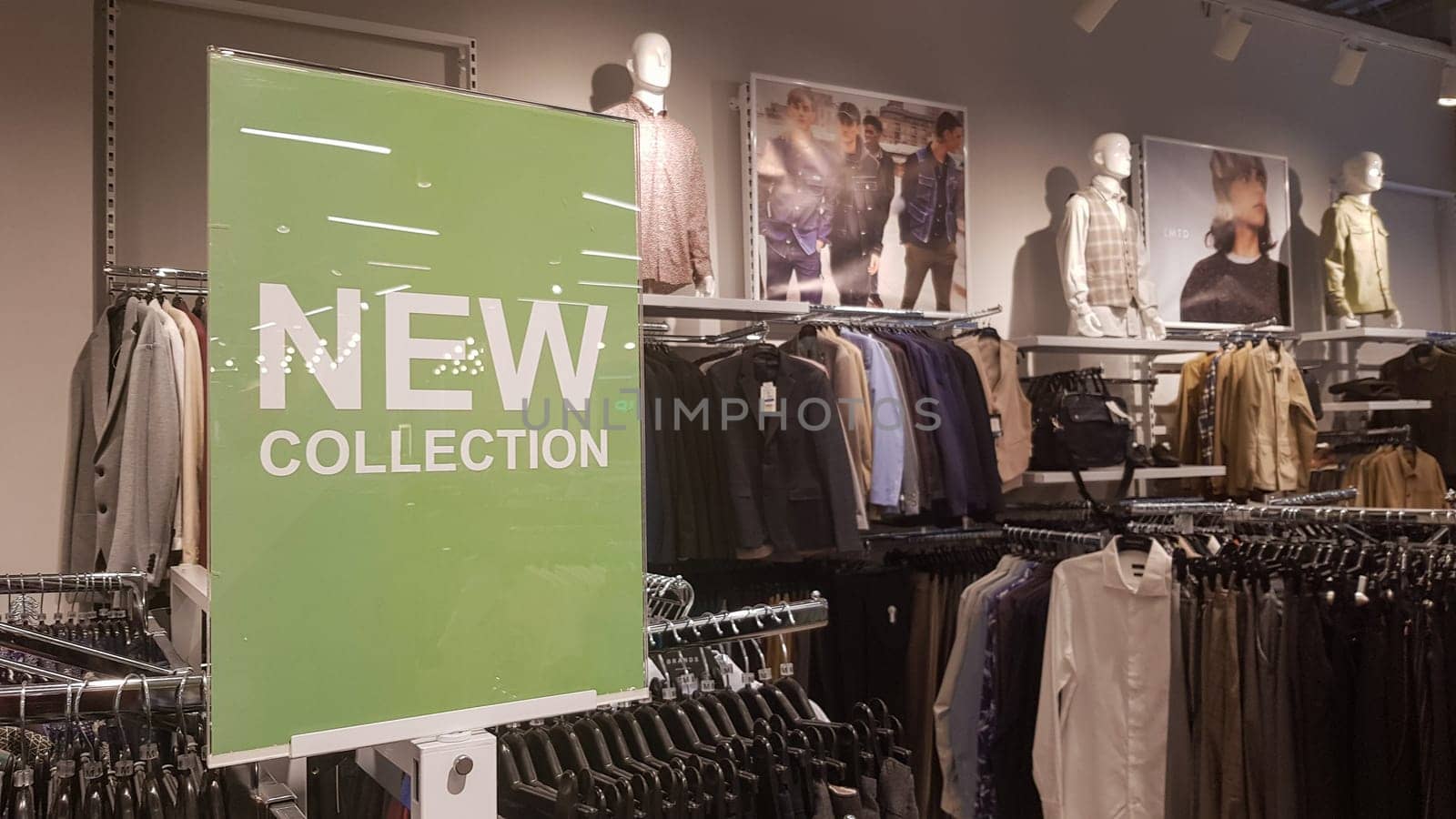 A sign in a men's clothing store with a sign NEW COLLECTION with light highlights. Conceptual luxury store, mall, store sale, retail store, outlet. Ukraine, Kyiv - May 23, 2022