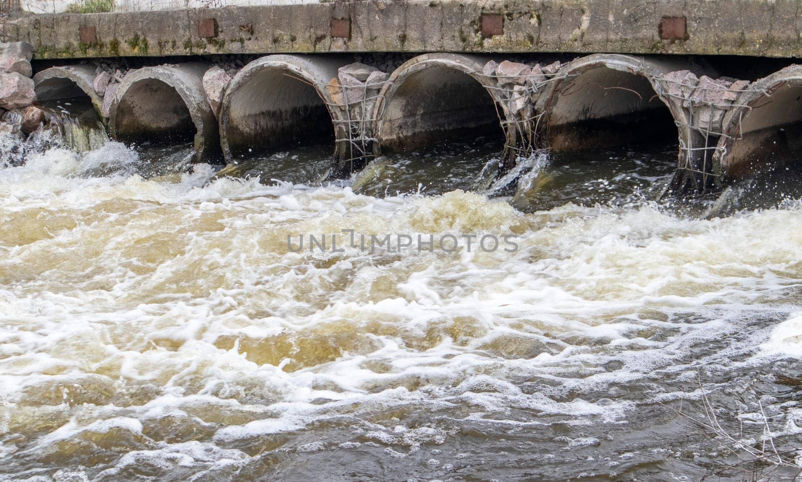 A concrete pipe that carries smelly, polluted sewage into the river through pipes. Pollution of the environment and water bodies. Ecological catastrophy. Hazardous waste water