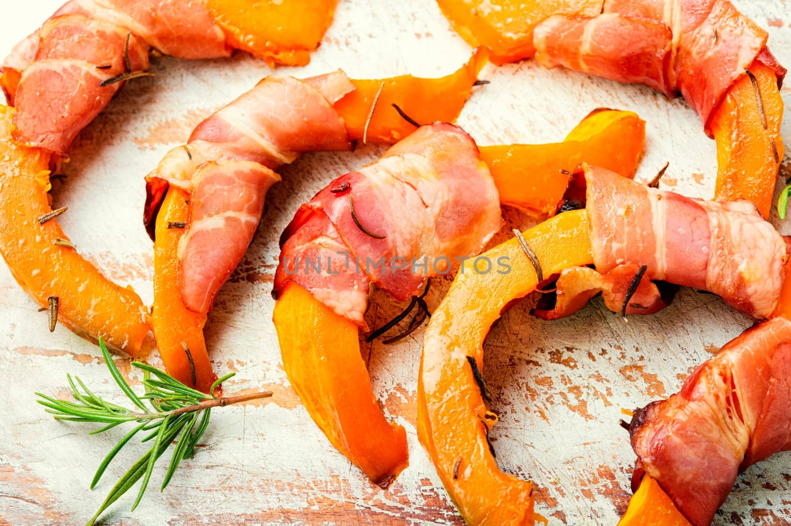 Autumn baked pumpkin pieces wrapped in bacon. Thanksgiving Day