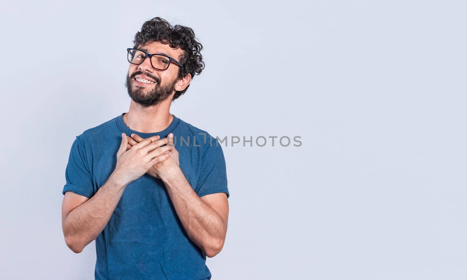 Grateful people smiling with hands on chest. Positive looking friendly handsome man with charming sincere smile feeling thankful, relaxed person with thanks gesture with hands on chest.