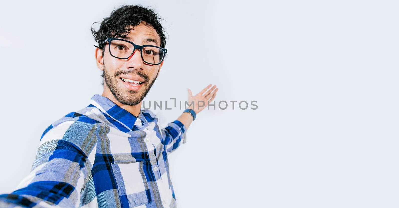 Man pointing back and presenting a product, Young man welcoming you isolated, person welcoming you with one hand. Friendly man inviting you to come