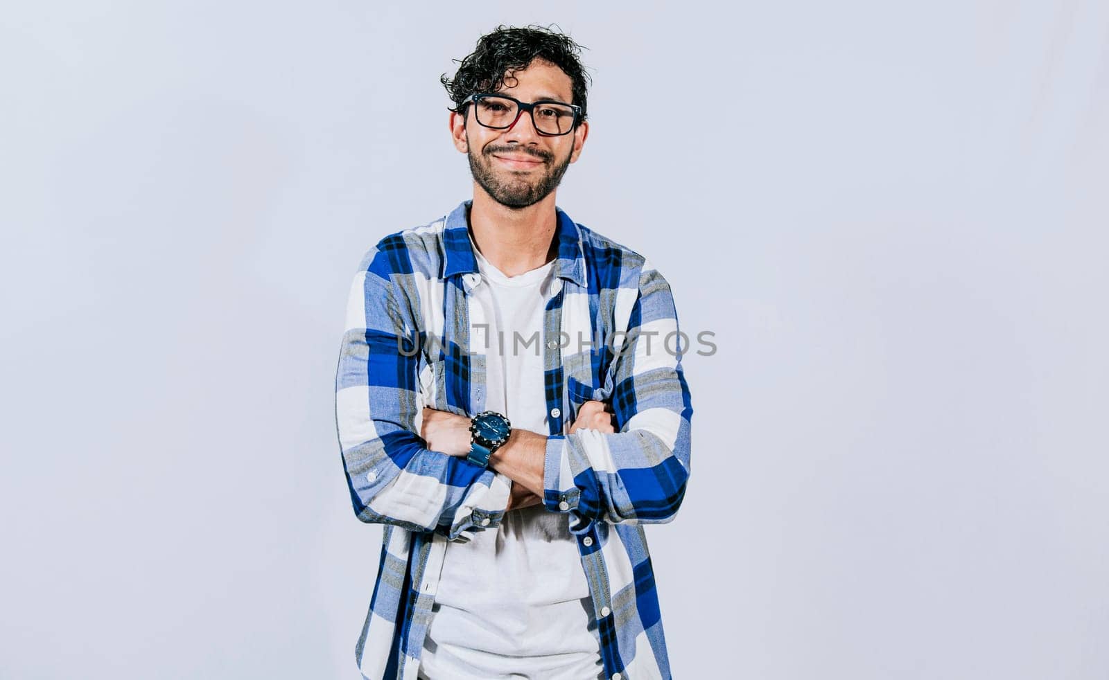 Friendly young man with crossed arms on isolated background. Teenage guy smiling with crossed arms isolated. Smiling bearded handsome man with crossed arms isolated