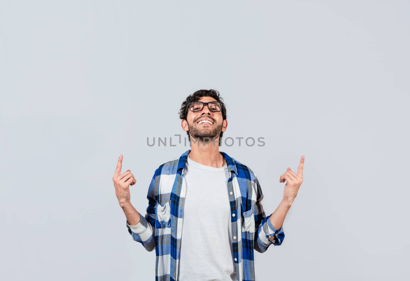 Smiling man in glasses pointing fingers up, People recommending something with fingers up isolated, Young man pointing an advertisement with fingers up
