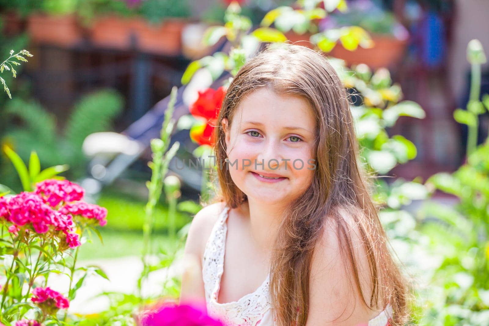 Portrait of a 10 year old girl enjoying the flower garden at home.