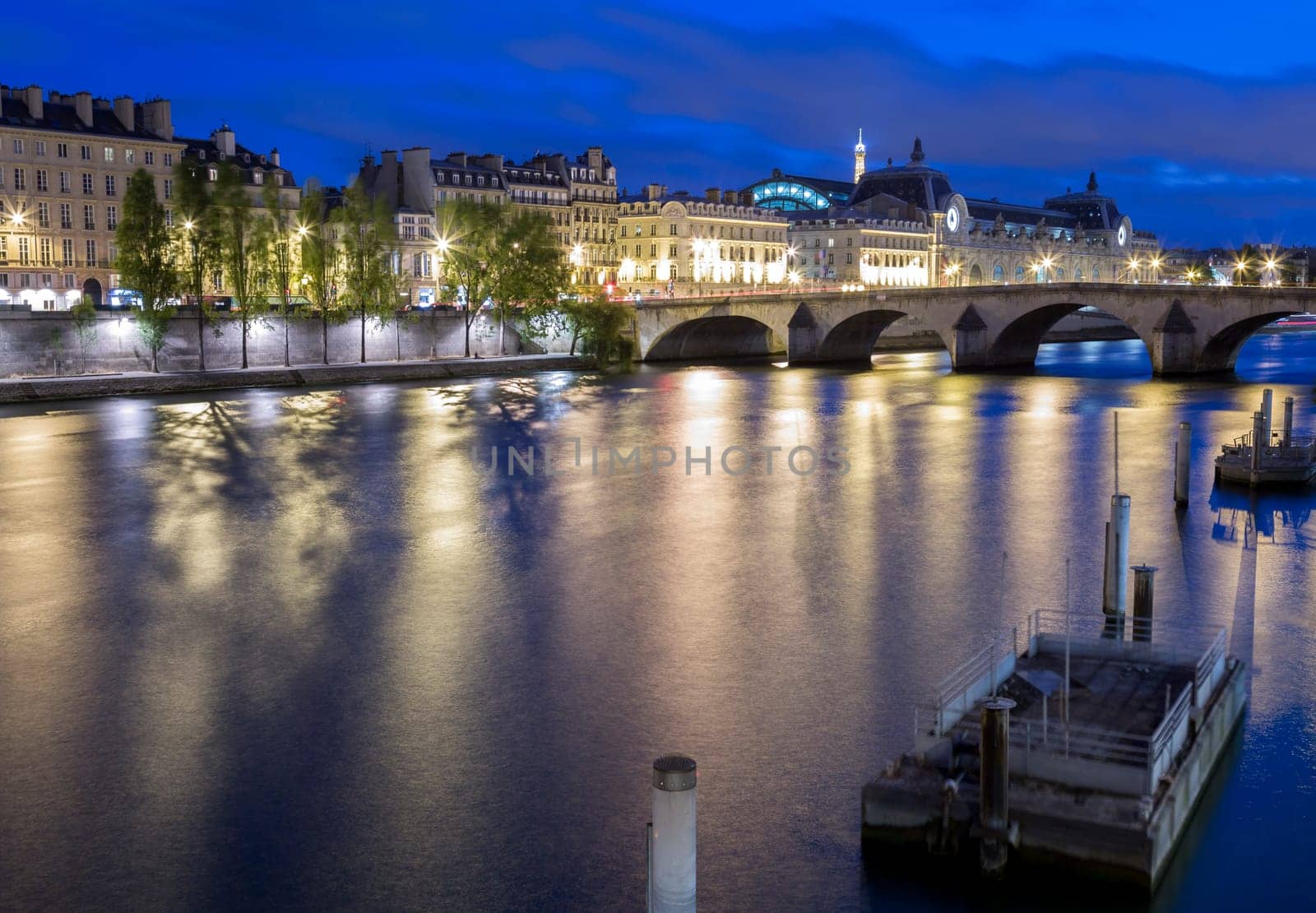 The River Seine in Paris, France overlooking downtown buildings and the Eiffel Tower in the distance.
